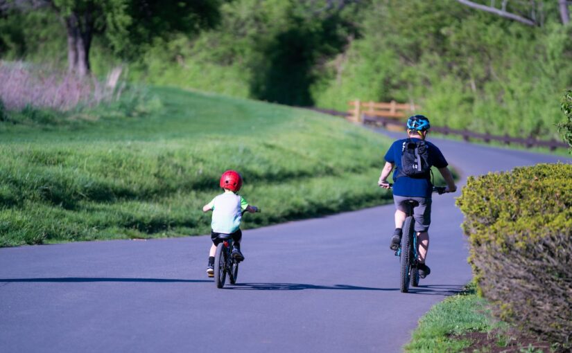 man in blue shirt riding bicycle on road during daytime