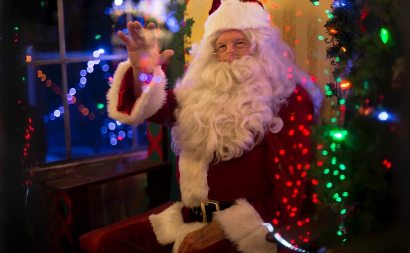 santa claus sitting beside lit tree