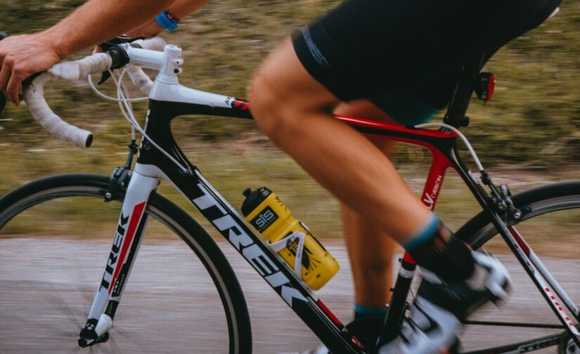 man in black t-shirt and orange shorts riding on black and white mountain bike