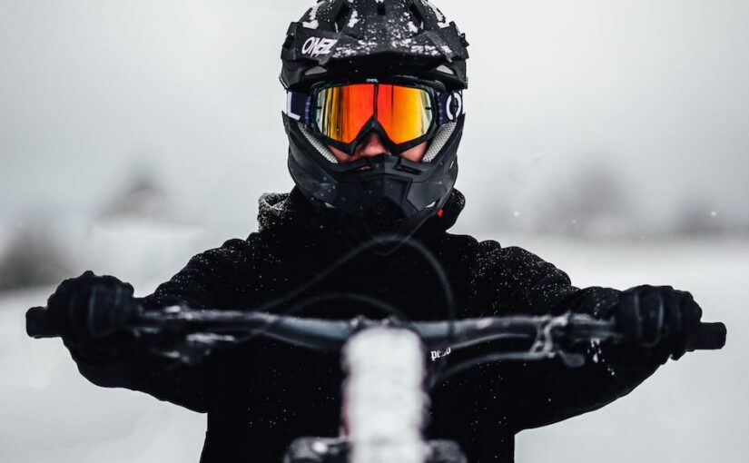 person in black jacket and black helmet riding black snowboard