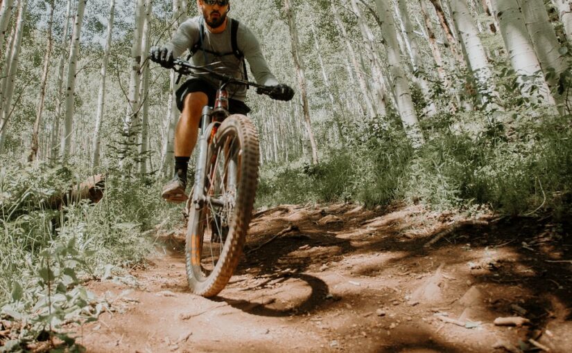 man riding on motorcycle in forest during daytime