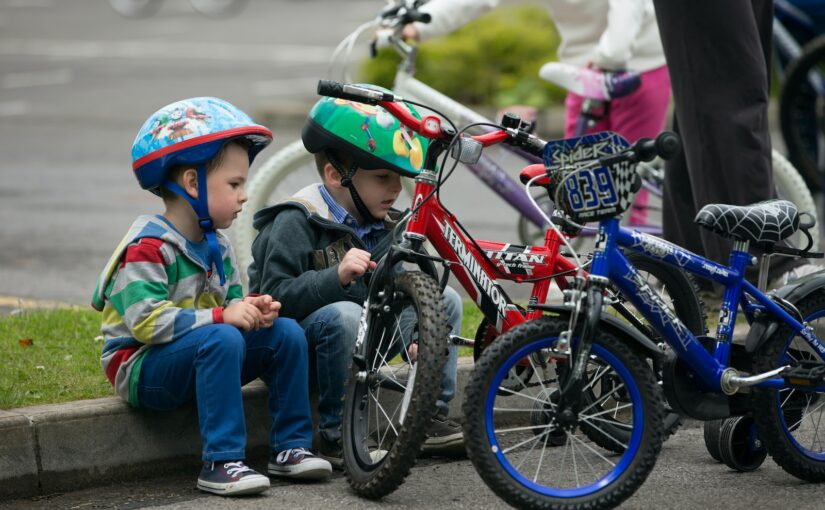 children riding on red mountain bike during daytime