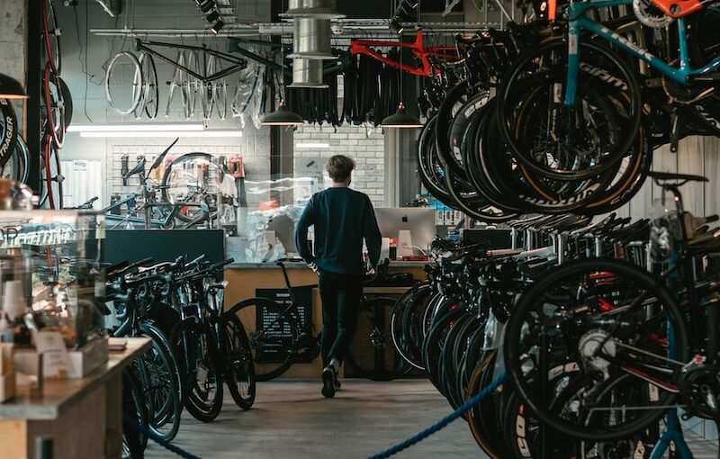 man in black t-shirt standing near black and red bicycle