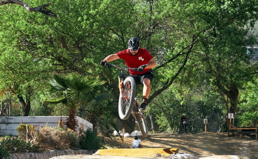 man in red shirt riding on bicycle